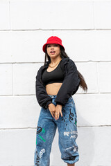 Young latin woman hip hop dancing in the street with a red hat, Panama, Central America - stock photo