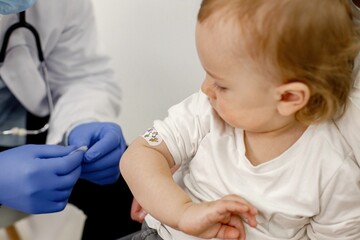 Fototapeta premium Cropped photo of a boy's shoulder with stick band-aid vaccination