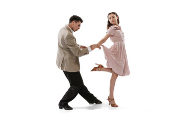 Young man and woman in vintage retro style outfits dancing social dance isolated on white background. Timeless traditions, 1960s american fashion style and art