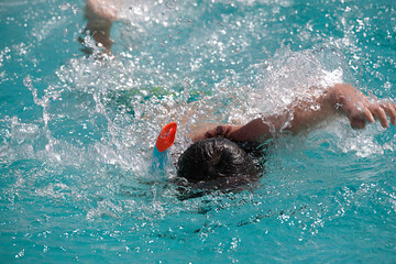 Young Boy Swimming. Copy Space. Boy with goggles swimming in crawl technique in swimming pool. Stock Image.