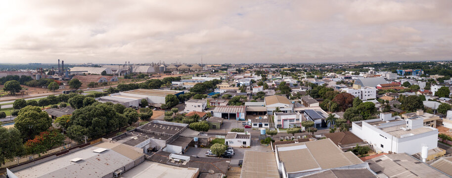 Drone aerial view of Sorriso city skyline, buildings, houses and BR 163 road on cloudy summer day, Amazon, Mato Grosso, Brazil. Concept of cityscape, landmark, architecture, logistics, transport.