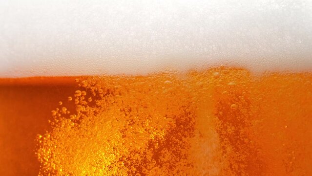 Super Slow Motion Shot of Rising Beer Bubbles and Fresh Foam Background at 1000fps.