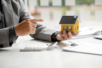 Real estate agents explain models of housing estates in projects to elaborate to clients,...