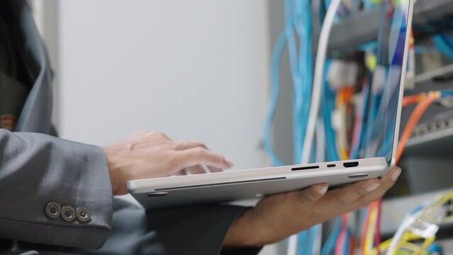 Male administrator it engineer conducts maintenance work in secure server room of cyberspace