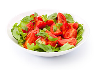 Green vegan salad from green leaves mix and tomato vegetables isolated on white background