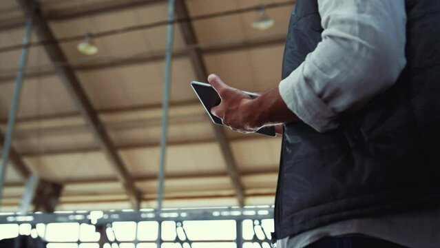 Dairy manager working cowshed alone. Worker hands holding pad computer closeup