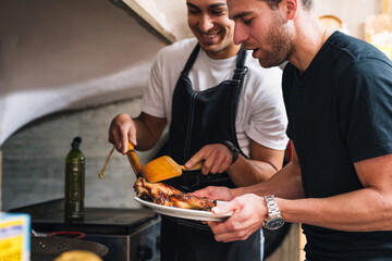 Couple of young friends plating a meat dish