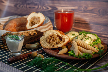 Pies with cabbage and sour cream on the festive table. Optional boiled new potatoes, corn, olives and tomato juice