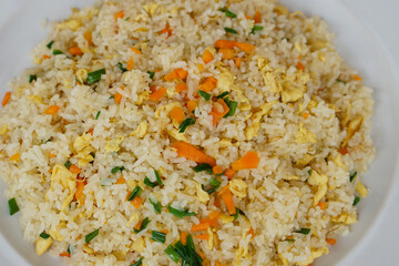 Closeup Thai homemade fried rice food on plate, mixed eggs, carrots and spring onion. Concept : Traditional Thai food. Easy and popular menu, can cook at home, restaurant.       