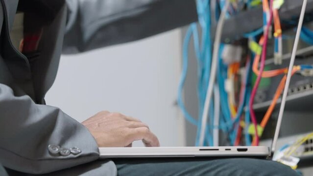 Male administrator it engineer conducts maintenance work in secure server room of cyberspace