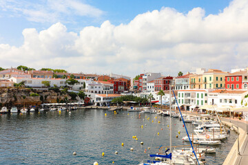 Fototapeta na wymiar Cales Fonts, en Menorca. Bonito pueblo con puerto pesquero y puerto deportivo, con 