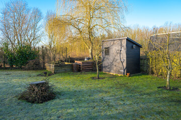 Garden shed and compost bins on a frosty morning