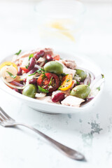 Salad with tuna, green olives and cherry tomatoes. Bright wooden background. Close up. 
