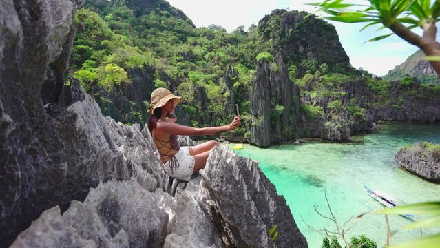 Woman Sitting On Limestone Rocks Taking Selfie With Smartphone