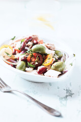 Salad with tuna, green olives and cherry tomatoes. Bright wooden background. Close up. 