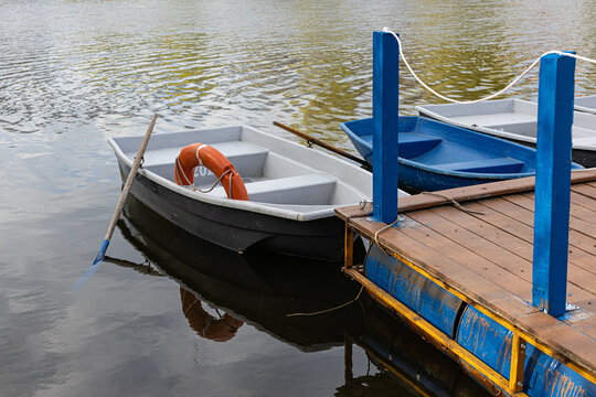 a boat with oars stands near a wooden pier