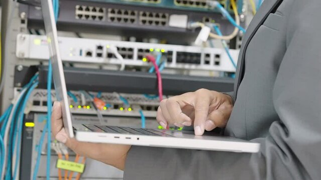 Male administrator it engineer conducts maintenance work in secure server room of cyberspace