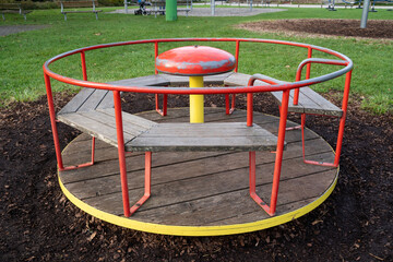 Round red and yellow carousel for children in the playground