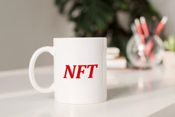 On the office work table mug with the text NFT. Business concept