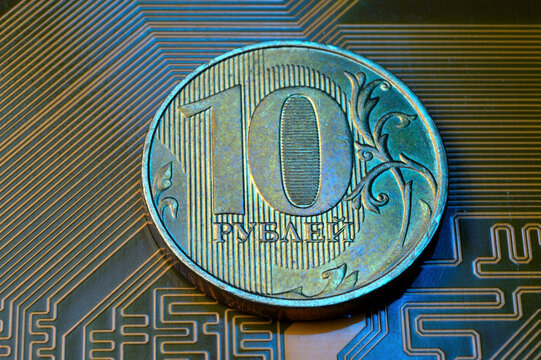 A coin with a face value of 10 rubles lies on a microcircuit. close-up. Translation of the inscription on the coin: "10 rubles" The concept of the digital economy in the Russian Federation