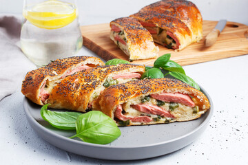 Traditional Italian stromboli stuffed with cheese, salami, green onions, sprinkled with poppy seeds.