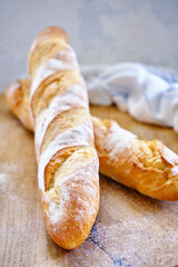 Fresh baguette with crispy crust on a wooden board close -up