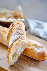 Fresh baguette with crispy crust on a wooden board close -up