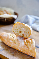 Fresh baguette with crispy crust on a wooden board close -up