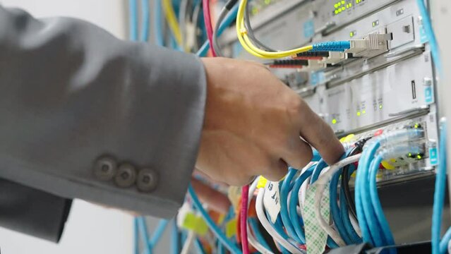 Male administrator it engineer conducts maintenance work in secure server room of cyberspace