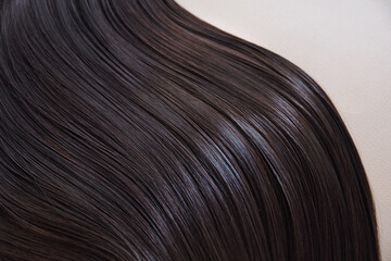 texture of well-groomed beautiful hair. Concept hairdresser spa salon. strand of brunette silky hair.