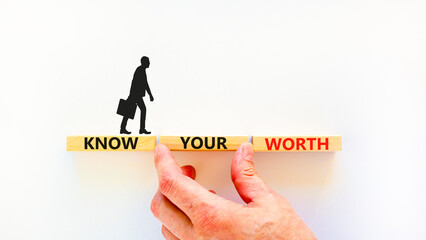 Know your worth symbol. Concept words Know your worth on wooden blocks. Businessman hand. Beautiful white table white background. Business and know your worth concept. Copy space.