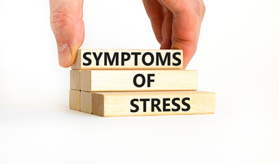 Symptoms of stress symbol. Concept words Symptoms of stress on wooden blocks. Beautiful white table white background. Doctor hand. Psychological business and Symptoms of stress concept. Copy space.