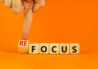 Focus or refocus symbol. Businessman turns wooden cubes and changes the concept word focus to...
