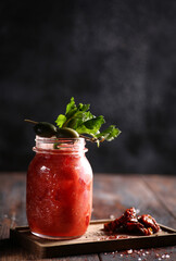 Drinks and beverage. Bloody Mary cocktail with celery and olives in a large transparent glass on an old wooden table. Rustic. Restaurant, bar. Background image, copy space