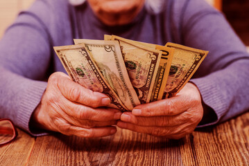 elderly woman counts the rest of the money. Wrinkled hands with money close-up