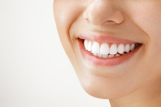 Beautiful female smile after teeth whitening procedure. Dental care. Dentistry concept.