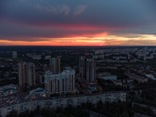 Naklejka na ściany i meble Vibrant sunset aerial view in city modern residential multistory district. 23 serpnia, Pavlovo Pole, Kharkiv, Ukraine. Fly at dusk, evening cloudscape and summer streets