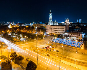 Fototapeta na wymiar Night city center streets with cars driving in long exposure. Aerial view on Dormition Cathedral with illumination. Downtown streets in Kharkiv, Ukraine