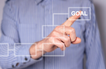 Businessman hand drawing digital scheme, flowchart. Screen showing algorithm with virtual blocks of working process and goal. Man forefinger pointing to objective. High quality photo