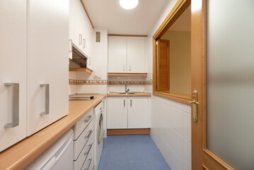Full kitchen with white appliances, matching washer, wood-colored countertop, and Venetian-style serving hatch