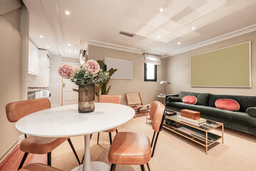 Living room with round white dining table, cream upholstered chairs and green velvet sofa