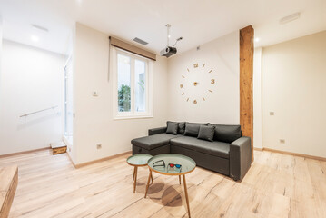 Cinema room with projector, sofa upholstered in dark fabric, 3d glasses and light brown parquet floors