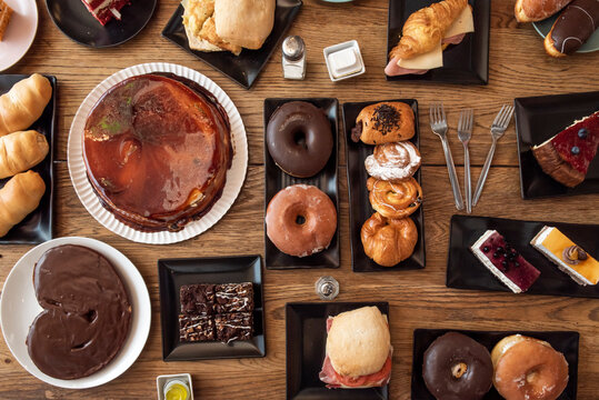top view image of sandwiches, donuts, pastries, cakes and sweets for breakfast and snack, a lot of chocolate, Venezuelan croissants, croissants with cheese and ham
