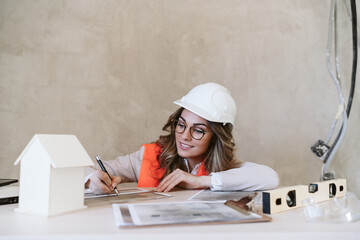 professional confident architect woman in construction site working on blueprints. Home renovation
