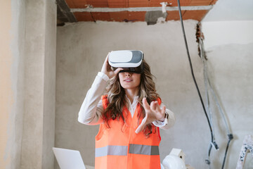 architect woman in construction site using virtual reality goggles working on VR blueprints