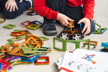 Sensory integration therapy - child constructing car and objects from colorful geometric magnetic...