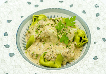 Plato de pasta fresca hecha de espinacas con salsa de queso