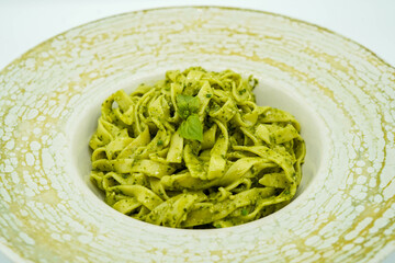 Plato de pasta fresca hecha de espinacas con salsa de queso