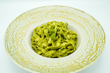 Plato de pasta fresca hecha de espinacas con salsa de queso