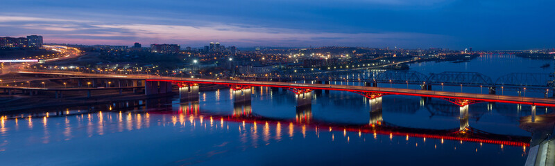 Panorama of the Siberian city of Krasnoyarsk. Night view from above on the Yenisei River and the Left Bank. New bridge